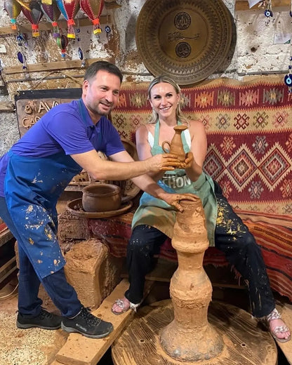 avanos çömlek yapım atölyesi​nde çanak yapan Şaban ve turist